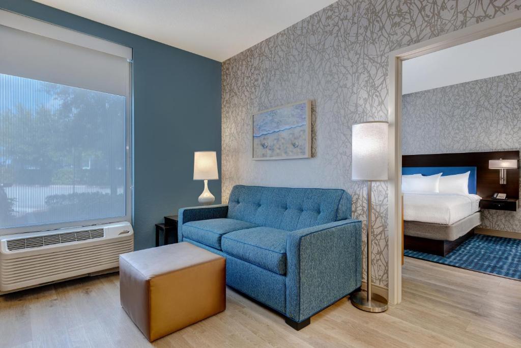 奥斯汀Home2 Suites By Hilton Austin East Side的客厅配有蓝色的沙发和床。