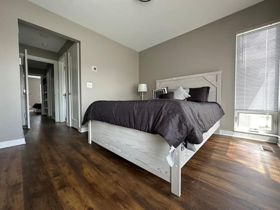 克利夫兰Luxury Downtown Townhome Unit 7的一间卧室设有一张大床,铺有木地板