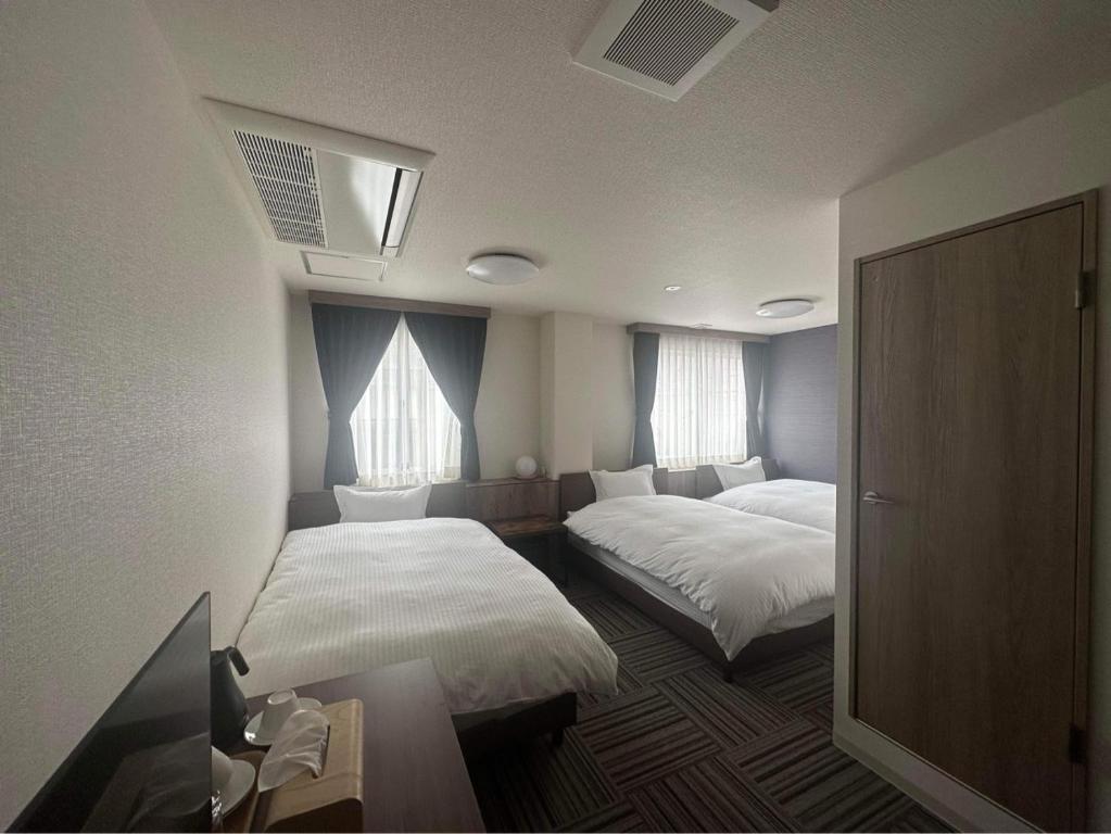 川口市WORLD ASAHI HOTEL的酒店客房带两张床和两个窗户