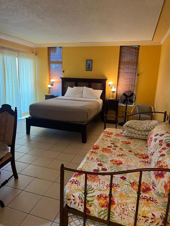 蒙特哥贝Sunny Tides at Montego Bay Club Resort的一间卧室配有两张床和两把椅子