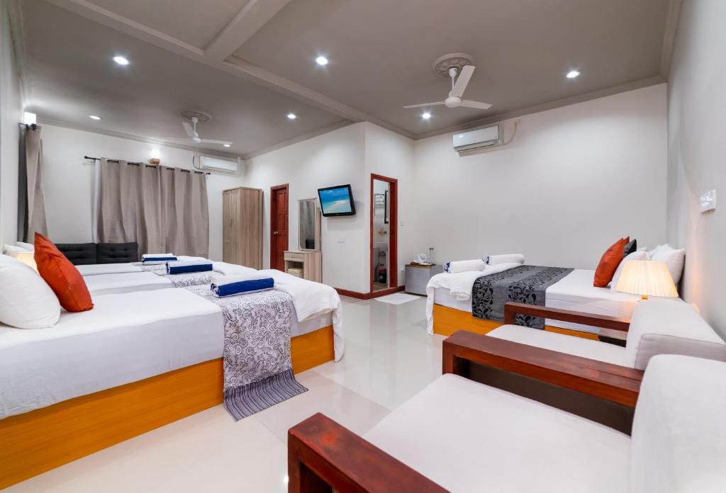 乌库拉斯Palm Oasis at Ukulhas的客房设有两张床、一张沙发和一台电视。