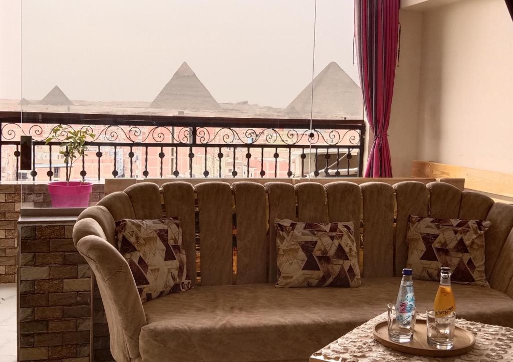 开罗Giza Pyramids View Apartment的一张沙发,桌子上有两瓶