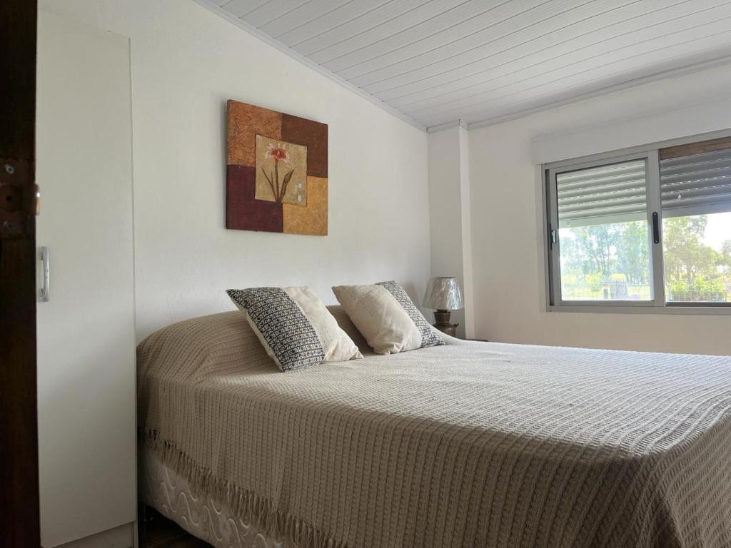 Treinta y Tres0 es 3 Uno的白色卧室配有一张带两个枕头的大床