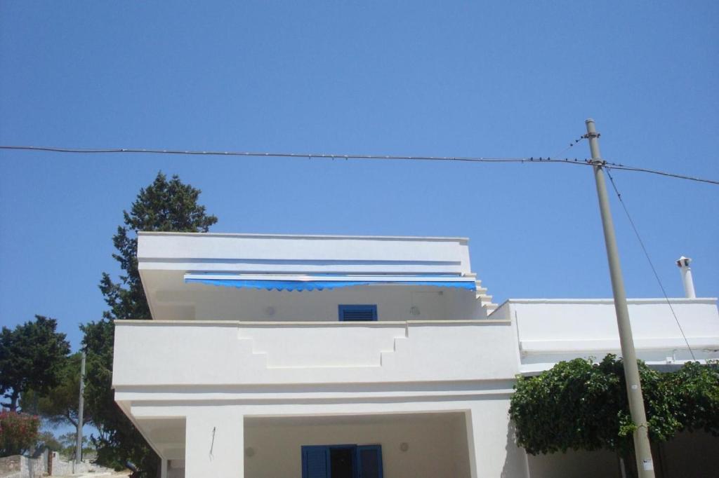 卡斯特里尼亚诺德尔卡波Wohnung in Marina Di Felloniche mit Kleinem Garten的白色的建筑,有蓝色的屋顶