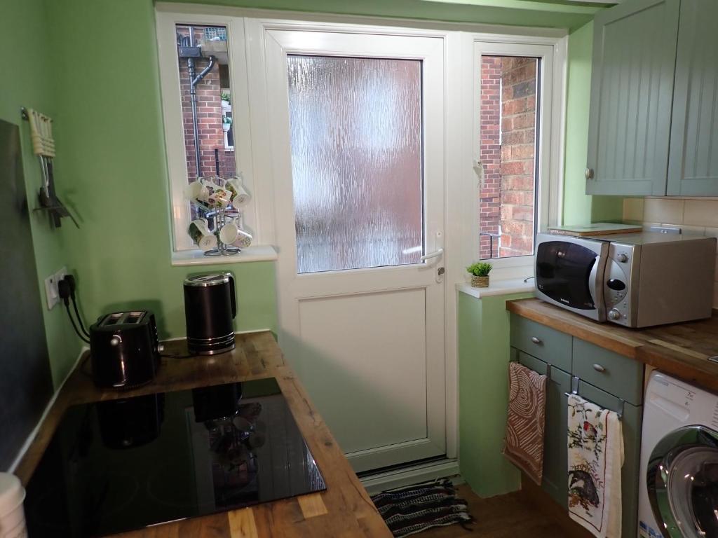 斯卡伯勒7 Weydale Court的带微波炉的小厨房和窗户。