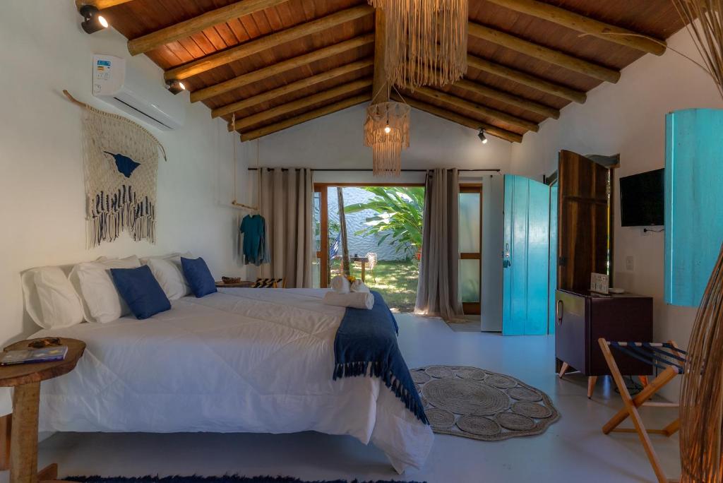 托兰克索Villa Mediterrâneo Trancoso的一间卧室设有一张床和一个大窗户