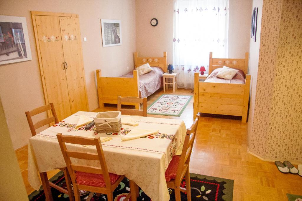 马里博尔Baščaršija Apartments & Rooms的一间带桌椅的用餐室和一间卧室
