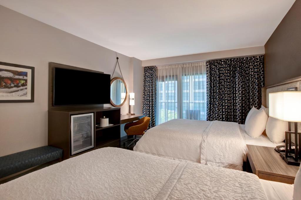 奥斯汀Hampton Inn Austin East Side的酒店客房设有两张床和一台平面电视。