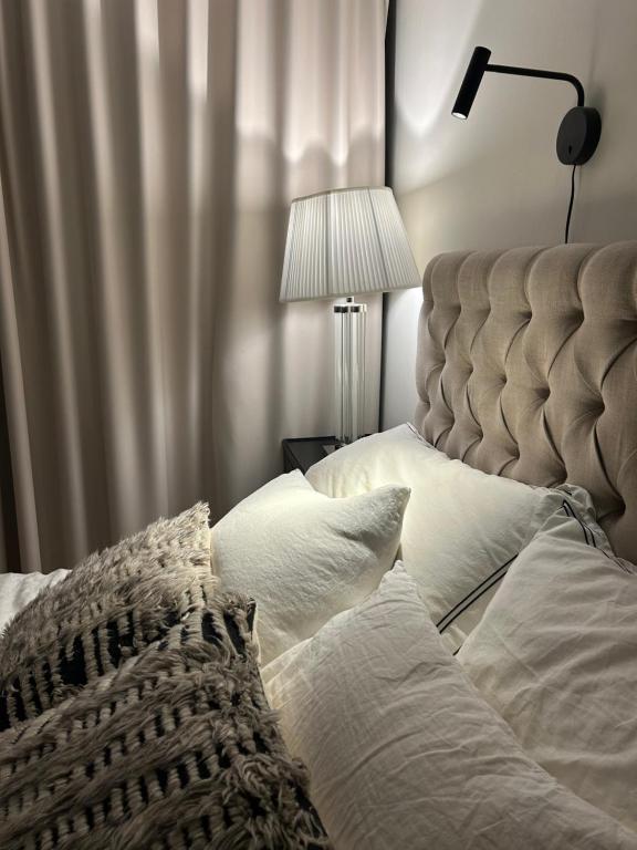 埃斯波Trekker's Haven: Noux National Park Retreat的一间卧室配有带白色枕头和灯的床