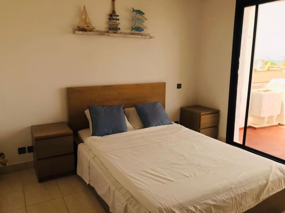 特马拉My Cosy Place Rabat - Maison harhoura vue mer的一间卧室配有一张带蓝色枕头的大床