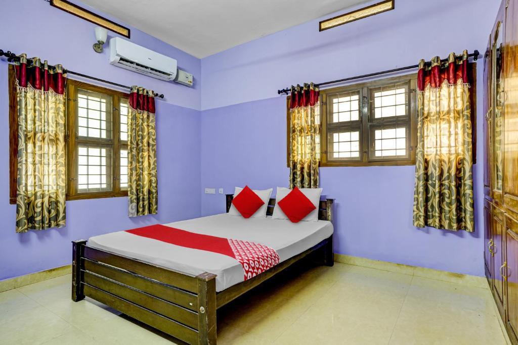 柴瑞海滩OYO Flagship Paradise villa的一间卧室配有红色枕头的床
