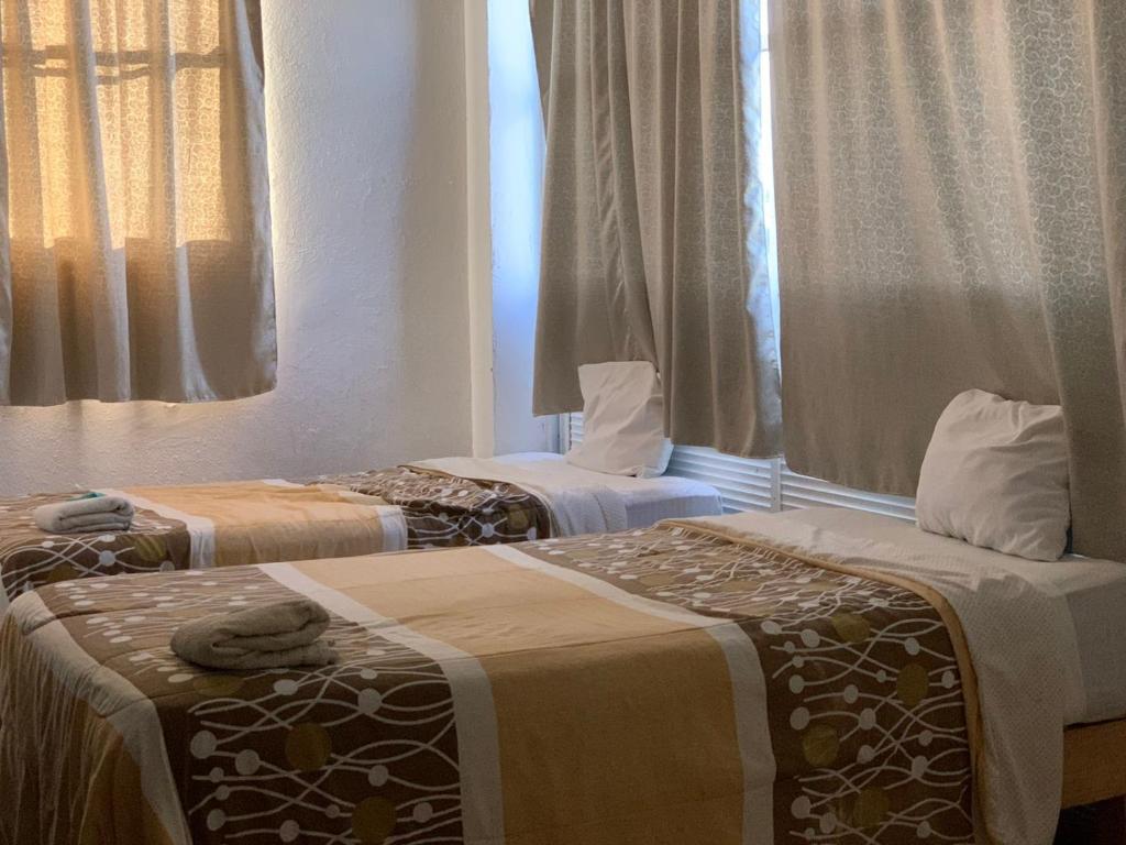 帕拉伊索HOTEL PUERTO REAL SUITES的两张睡床彼此相邻,位于一个房间里