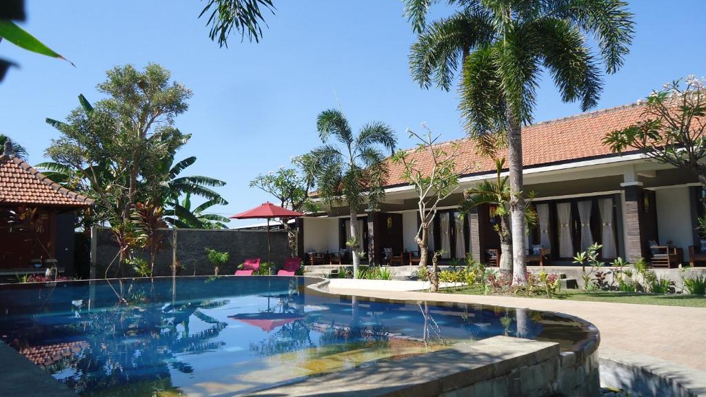 罗威那普拉布套房酒店的一座带游泳池的度假村,位于一座建筑前