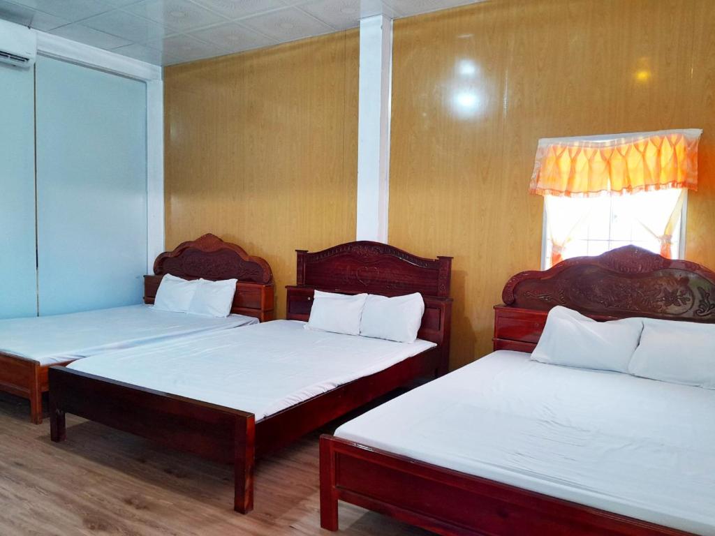 Rạch TàuHomestay Nguyễn Hùng的一间设有两张带白色床单的床的房间