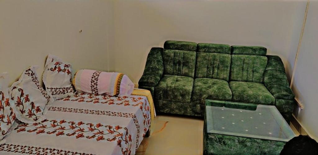 菩提伽耶Glamour Palace的客厅配有绿色沙发和椅子