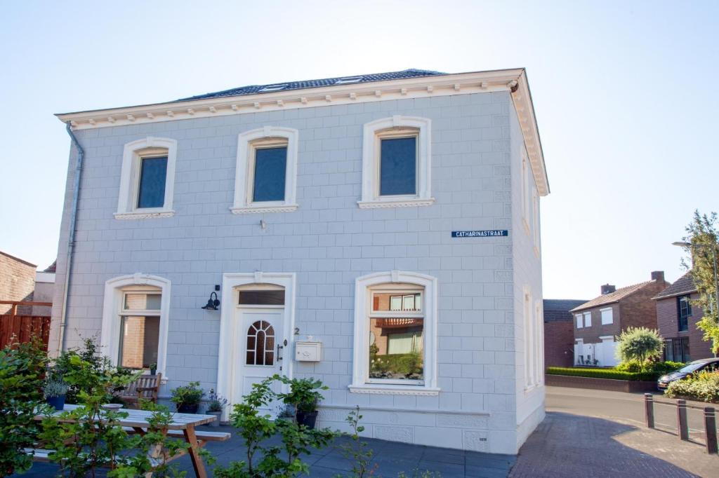 艾斯登Stijlvolle @ luxe vrijstaande woning Maastricht的白色的房子,街上有白色的窗户