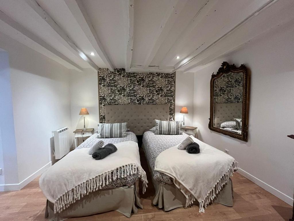 谢夫勒斯谢夫勒斯度假屋的一间卧室配有两张床和镜子