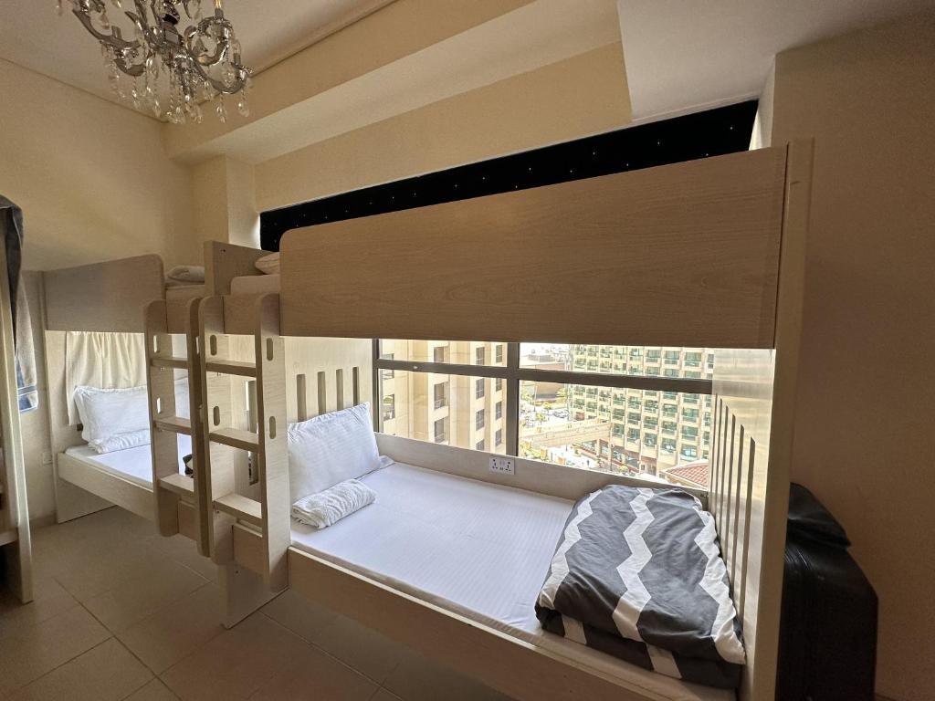 迪拜Bollywood Beach Hostel的客房设有两张双层床和窗户。