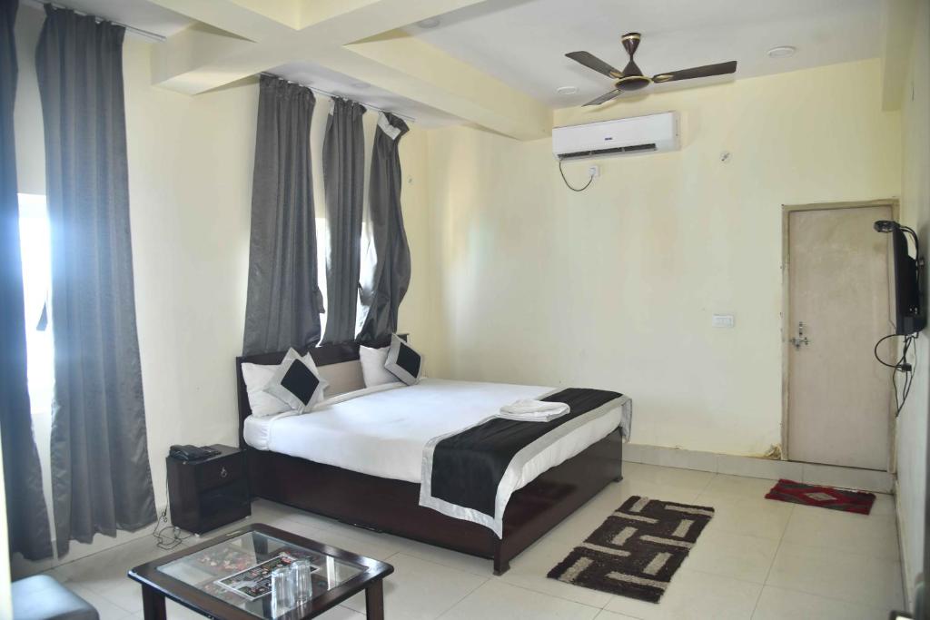 德奥加尔Hotel Buddha Vibrant的一间卧室配有一张带吊扇的床