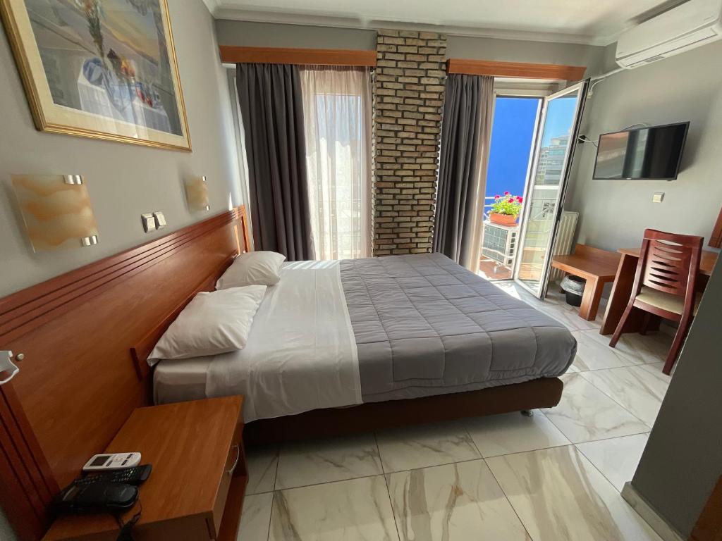 比雷埃夫斯Piraeus Acropole Hotel的一间卧室配有一张床铺和一张桌子,另一间卧室配有