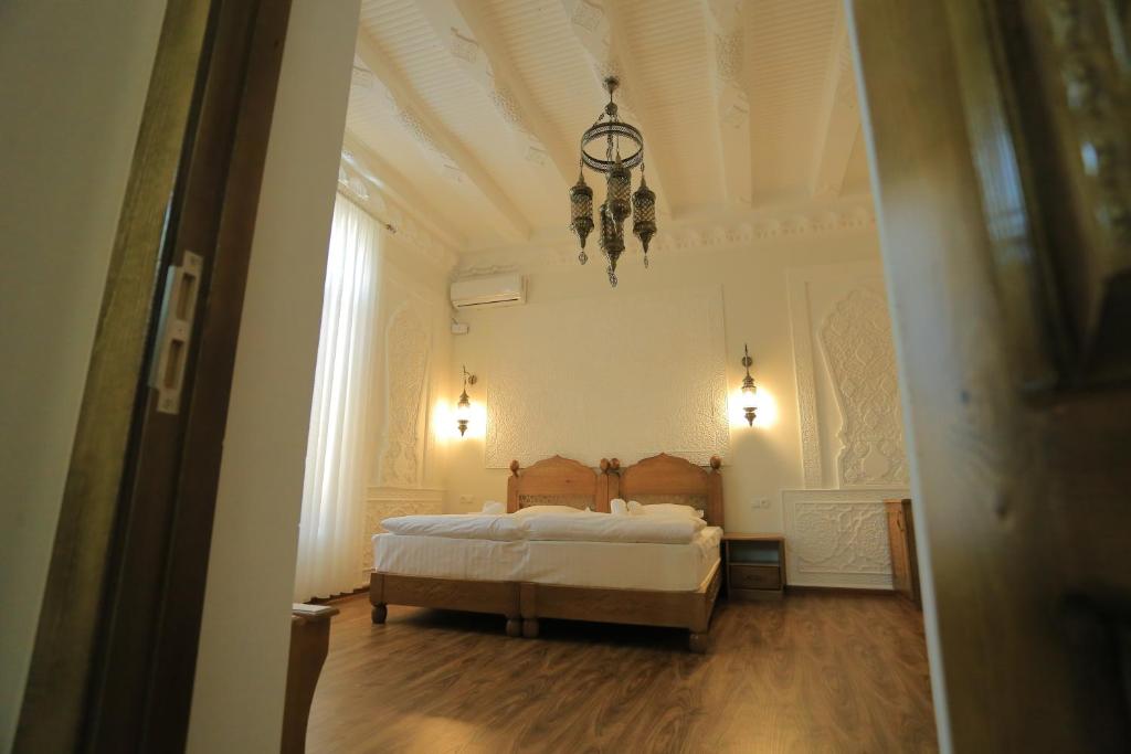 布哈拉Best Hotel Muqaddam的一间卧室配有一张床和一个吊灯