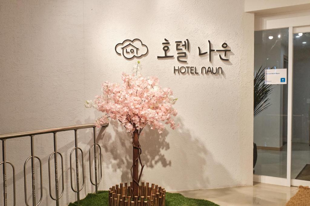 群山市Gunsan Hotel Naun的墙上有粉红色花朵的树