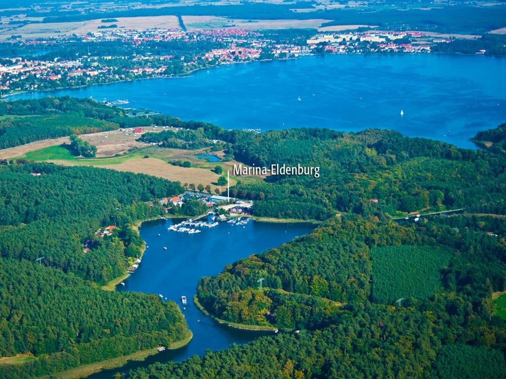 瓦伦Marina Eldenburg - Ferienhäuser und Bootsverleih am Tor zur Müritz的河流和森林的空中景观