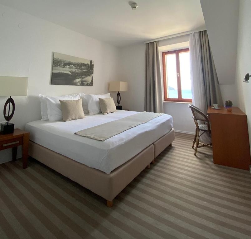 洛帕德Hotel Glavovic的卧室设有一张白色大床和一扇窗户。