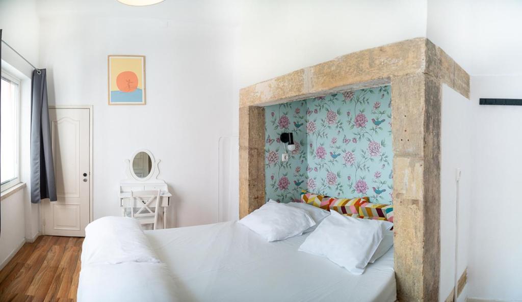 里斯本Safestay Lisbon Bairro Alto的卧室配有白色床和花卉床头板