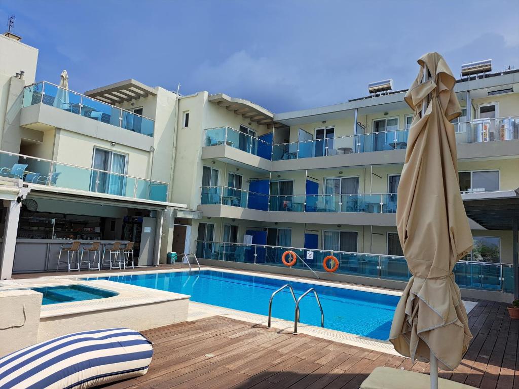 科斯镇布里斯托海景公寓式酒店的一座大楼旁的带遮阳伞的游泳池