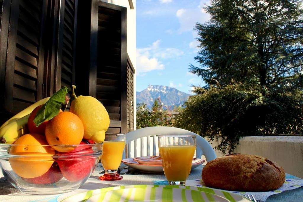 卡尔切拉尼卡阿拉戈[Fronte lago]ResidenceGarden, moderno appartamento的一张桌子,上面放着一碗水果和橙汁