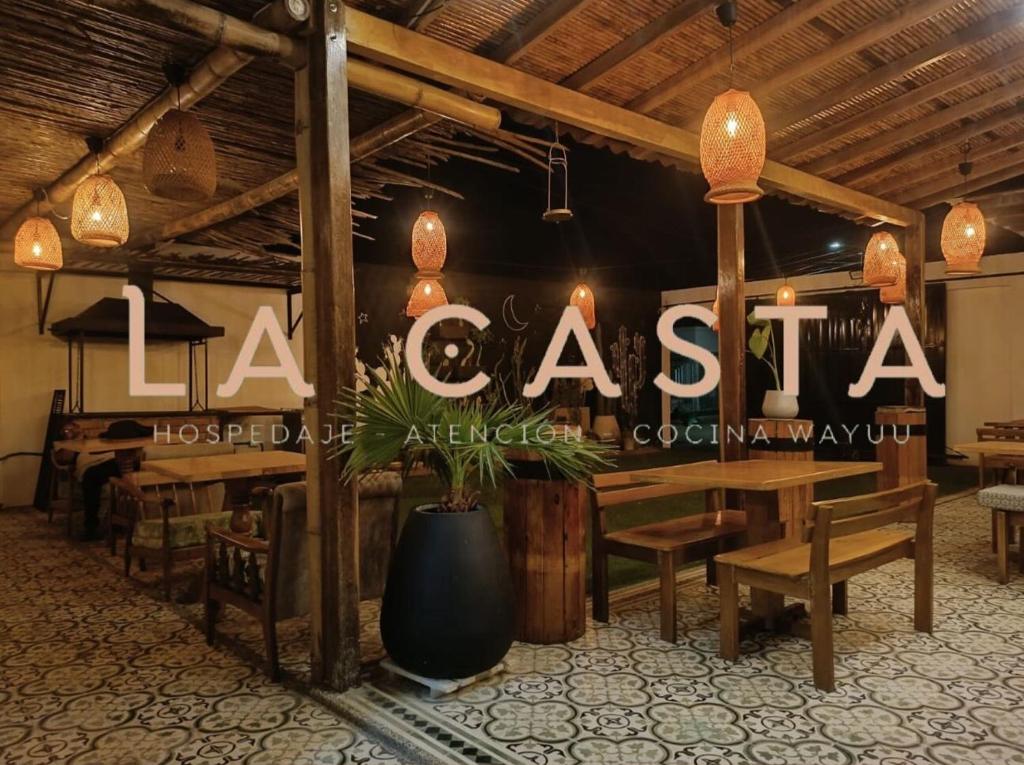 CamaronesHostal La Casta的餐厅设有木桌和阅读la casita的标志