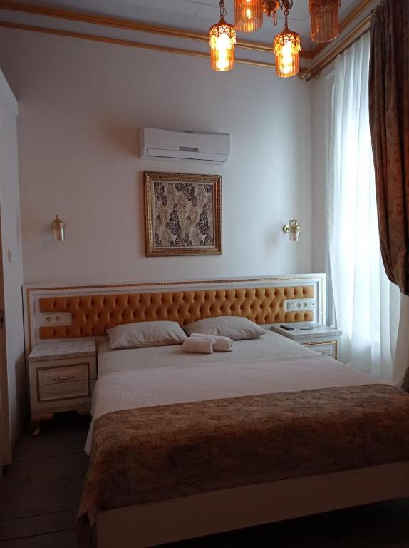 KarşıyakaBUDAKZADE KONAĞI OTEL-RESTAURANT 1841的一间卧室配有一张大床和木制床头板
