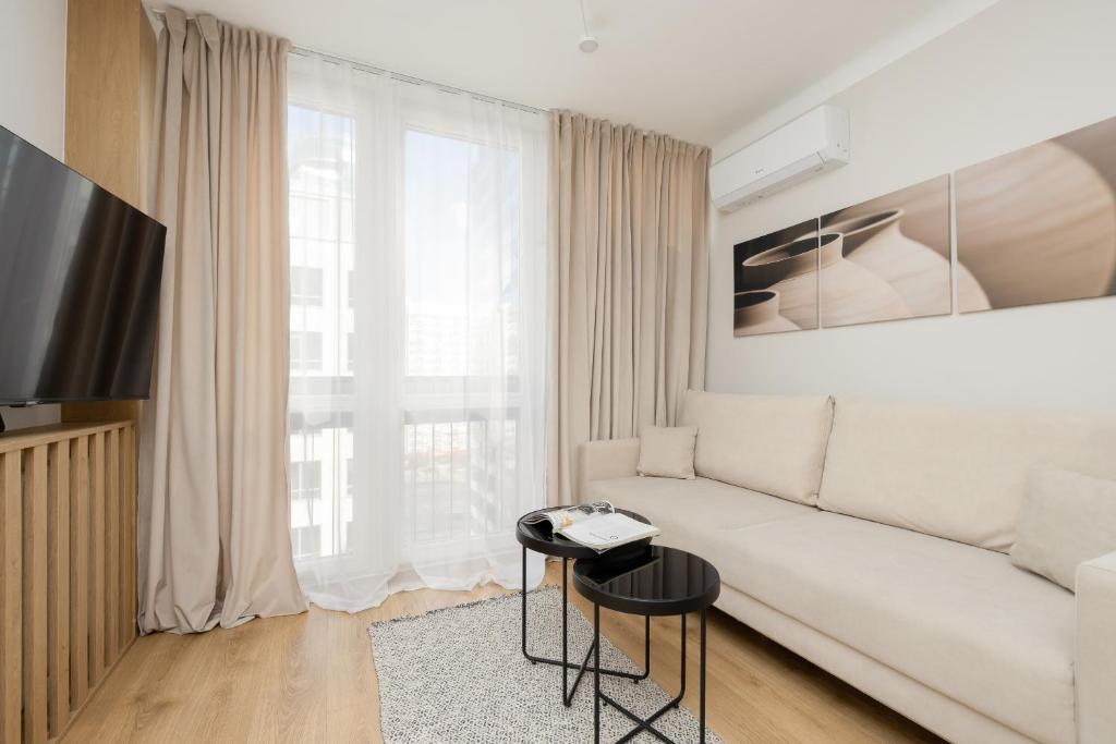 华沙Pereca Stylish Apartment Warsaw & Air Conditioning by Rent like home的客厅配有白色的沙发和桌子