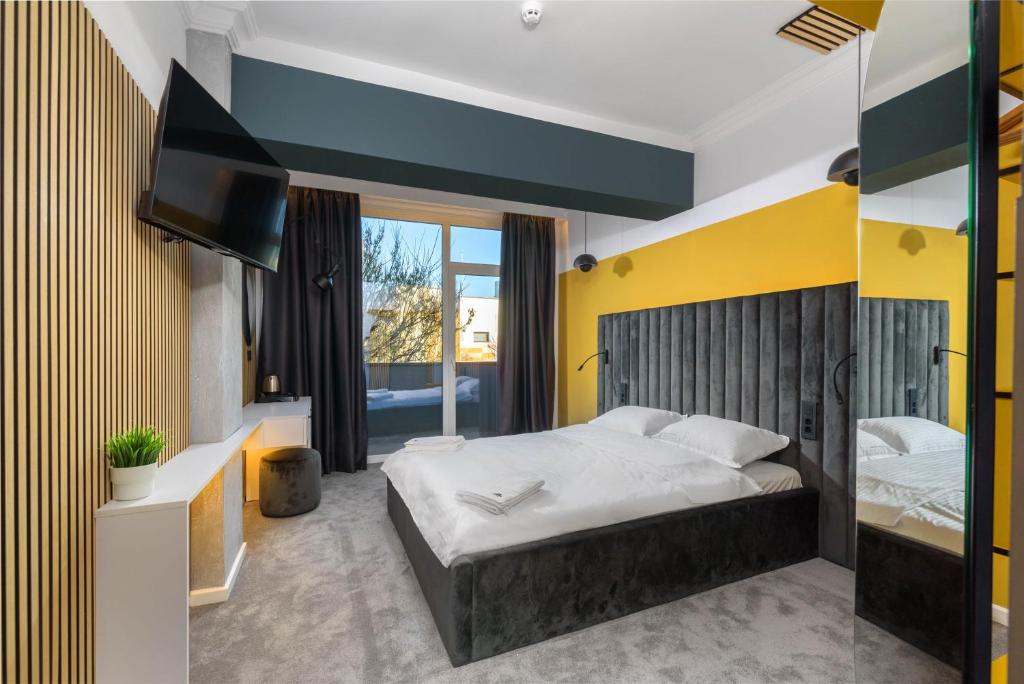 蒂米什瓦拉URBAN BUDGET HOTEL的一间卧室设有一张大床和黄色的墙壁