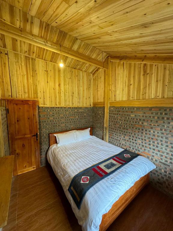 萨帕Chacha's House的木制客房内的一间卧室,配有一张床