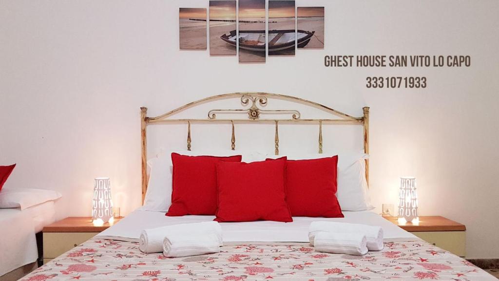圣维托罗卡波Guest House San Vito Lo Capo的一间卧室配有一张带红色枕头的大床