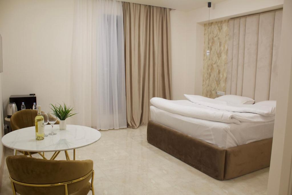 ArbatʼLux Plaza Hotel的一间卧室配有一张大床和一张桌子