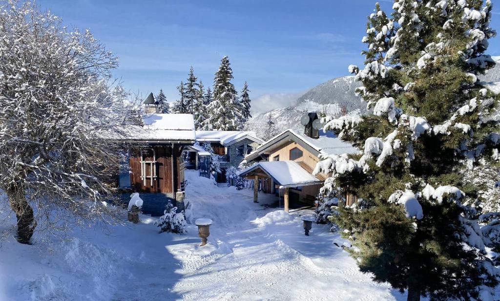 谷雪维尔Le Hameau de Marcandou的雪中小屋,有雪覆盖的树木