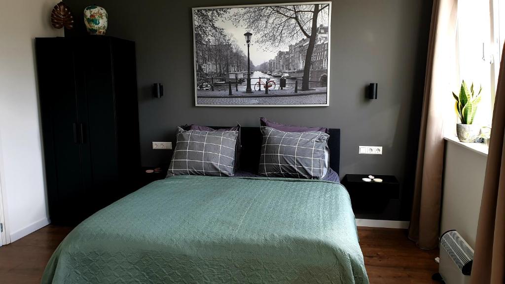 阿姆斯特丹Amor Guesthouse的一间卧室配有一张带绿色棉被的床