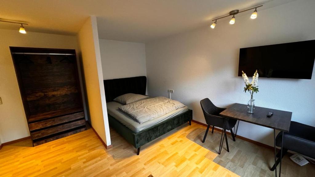 斯图加特Apartment 1 im Lehenviertel的一间卧室配有一张床、一张桌子和一张书桌