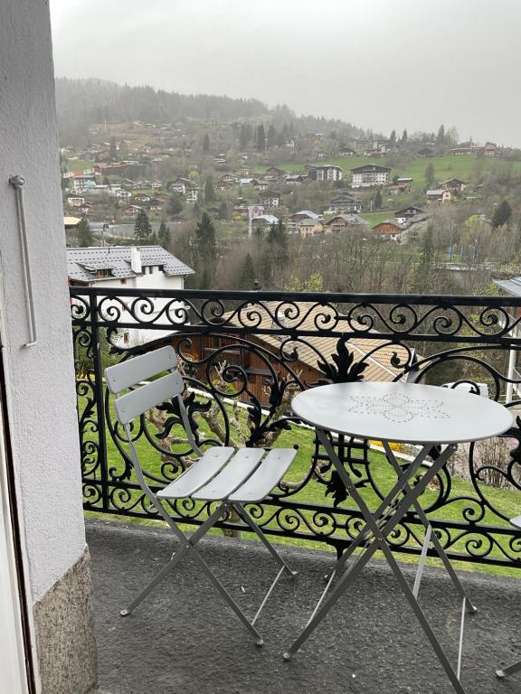 圣热尔韦莱班Chambre centre Saint-Gervais Mont-Blanc的阳台设有两张桌子,享有城市美景