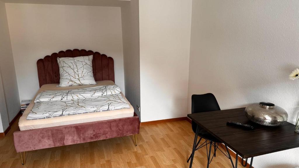 斯图加特Apartment 3 im Lehenviertel的一间小卧室,配有一张床和一张桌子