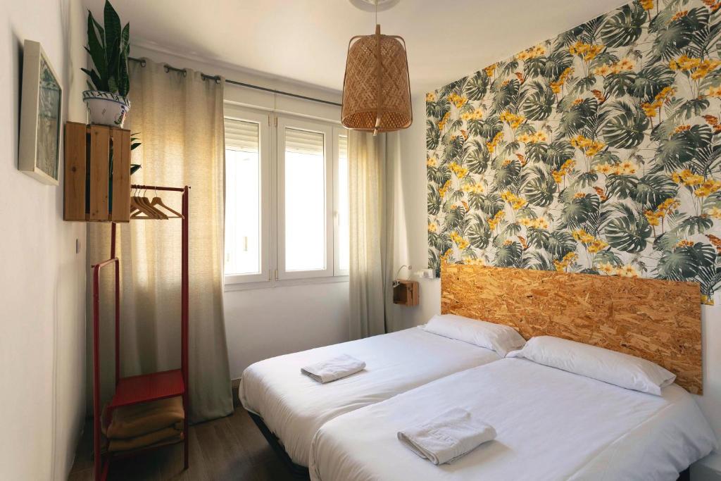 奥维多Green Hostel Oviedo的一间卧室设有两张床和花卉墙
