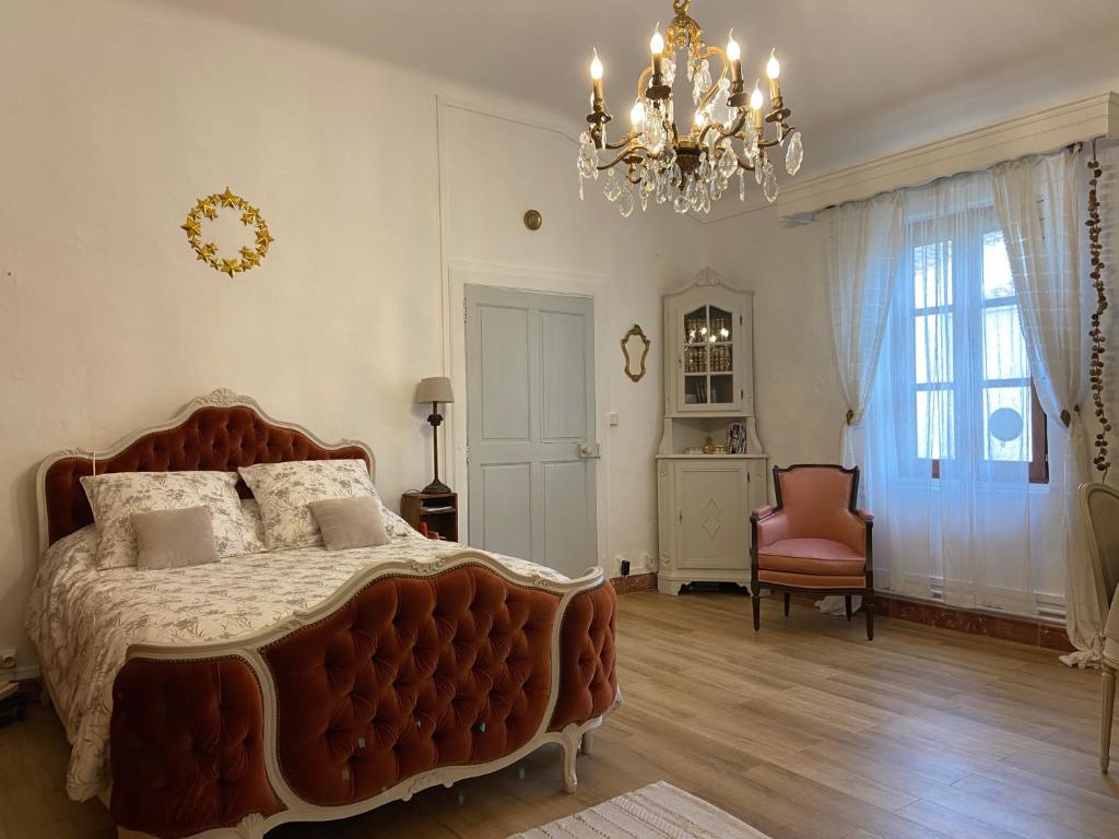 GaronsMaison 1823 - Suites de charme à Garons的一间卧室配有一张大床和一个吊灯。