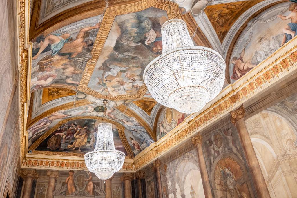 罗马PALAZZO ROMA的天花板上挂有绘画作品的2个吊灯