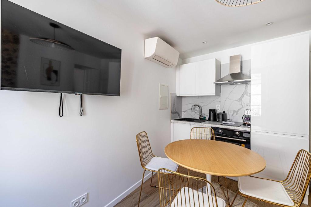 戛纳Cozy renovated 1 bedroom Suquet Cannes Center - 1BR的一个带木桌和椅子的小厨房