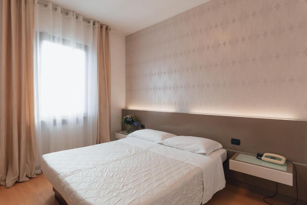 多索博诺家托巴多酒店的卧室配有白色的床和窗户。