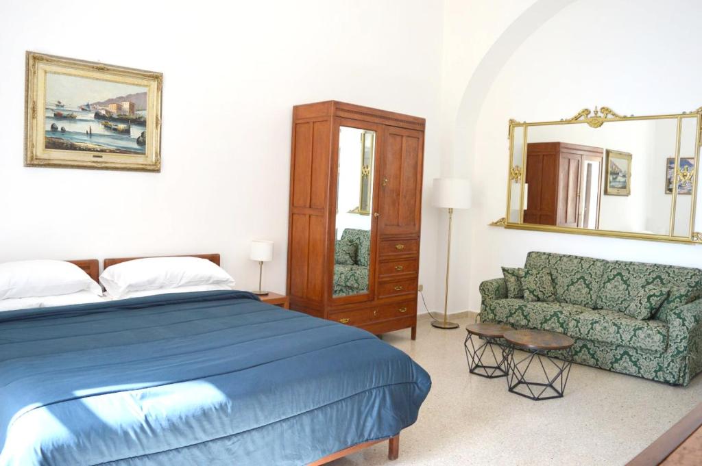 萨莱诺Plaza Apartment的一间卧室配有一张床、一张沙发和一面镜子