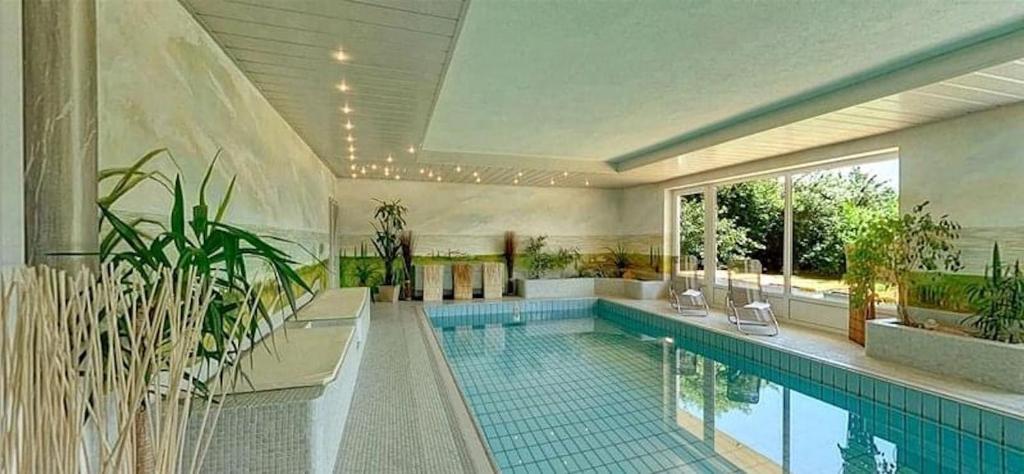沃尔特湖畔韦尔登Villa Martini Boutiquehotel的一座种植了植物的大型游泳池
